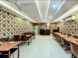 Un comedor con mesas y sillas de madera. en HOTEL THE AVENUE, en Gamhāria