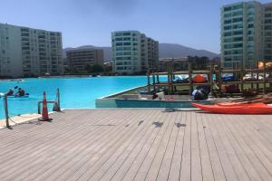 a large swimming pool with a red boat on a dock at PAPUDO LAGUNA in Papudo