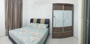 セリ・マンジュンにあるHOMESTAY IMPIAN QASEH MANJUNG (MUSLIM)のベッドルーム1室(ベッド1台付)、木製キャビネットが備わります。