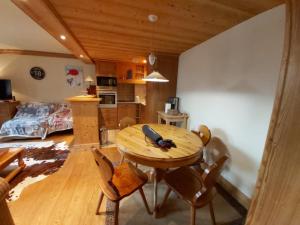 a kitchen and dining room with a wooden table and chairs at Appartement Val-d'Isère, 2 pièces, 4 personnes - FR-1-518-100 in Val-d'Isère
