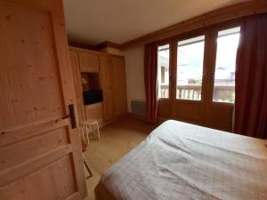 a bedroom with a bed and a large window at Appartement Val-d'Isère, 2 pièces, 4 personnes - FR-1-518-100 in Val-d'Isère