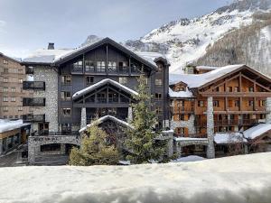 a large building with snow in front of a mountain at Appartement Val-d'Isère, 4 pièces, 6 personnes - FR-1-518-87 in Val-d'Isère