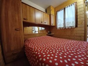 a bedroom with a bed with a red comforter at Charmant 2 pièces avec balcon et parking au Col du Corbier - FR-1-573-107 in Le Biot