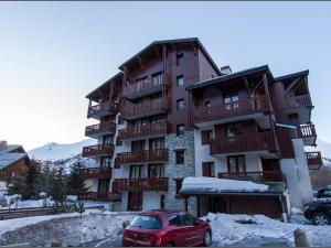 czerwony samochód zaparkowany przed budynkiem w obiekcie Studio Mezzanine - 5 Pers, Centre Val d'Isère, 10 min des Pistes, Balcon Ouest - FR-1-518-117 w mieście Val dʼIsère +3 zdjęcia