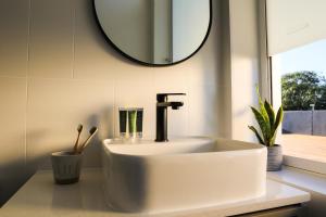 a white sink in a bathroom with a mirror at Beach Road Hotel in Sydney