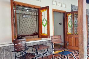 a porch with two chairs and stained glass windows at Omah Pitoe Yogya Homestay in Yogyakarta