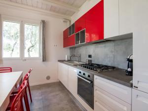a kitchen with red cabinets and a stove top oven at Holiday Home in Marche region with Private Swimming Pool in Ostra Vetere