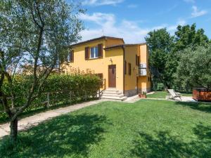 a yellow house with a fence and a yard at Holiday Home in Marche region with Private Swimming Pool in Ostra Vetere