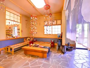 ein Wohnzimmer mit Bänken und Tischen in der Unterkunft Takanosukan in Sekikawa