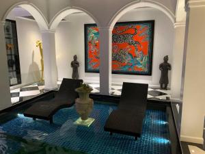 two chairs and a vase in a room with paintings at Golden Gorilla Villa with private pool & jacuzzi in Angeles