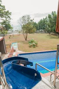 a swimming pool with a slide next to a resort at Shenanigans Glamping Resort in Zamboanguita