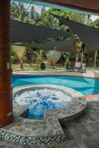 a swimming pool with a table and an umbrella at Shenanigans Glamping Resort in Zamboanguita