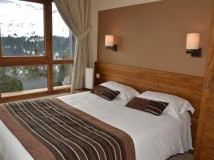 ein Schlafzimmer mit großem Bett und Fenster in der Unterkunft Appartement 3 pièces avec cheminée, accès pistes, piscine, spa, WIFI - Flaine Montsoleil - FR-1-425-140 in Flaine