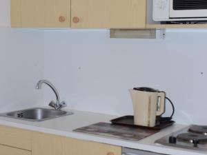 eine Küche mit einer Spüle und einer Kaffeekanne auf der Theke in der Unterkunft Studio Flaine, 1 pièce, 4 personnes - FR-1-425-174 in Flaine