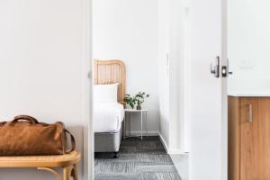 a door leading to a bedroom with a bed and a table at The Ned Ryan Motel in Boorowa