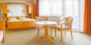 ein Hotelzimmer mit einem Tisch und einem Bett in der Unterkunft Gasthof und Pension zum Kreuz in Lautenbach