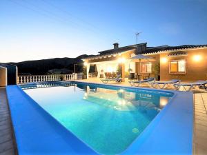 a swimming pool in front of a house at Spacious Home in Teulada in Teulada