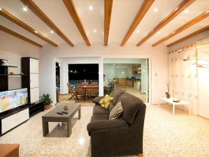 a living room with a couch and a tv at Spacious Home in Teulada in Teulada