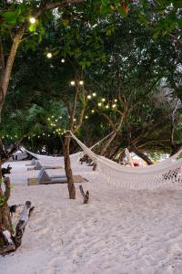 a hammock on a beach with trees and lights at Le Pirate Gili Meno - Adults Only in Gili Meno