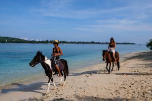 two girls riding horses on the beach at Le Pirate Gili Meno - Adults Only in Gili Meno