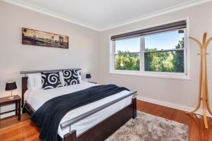 a white bedroom with a bed and a window at Lake Wendouree Luxury Apartments in Ballarat