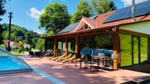 a house with a deck with chairs and a pool at Chalupa u Bohumila in Rybná nad Zdobnicí