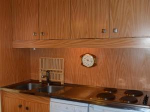 uma cozinha com um lavatório e um relógio na parede em Studio Flaine, 1 pièce, 4 personnes - FR-1-425-178 em Flaine