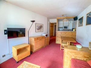 a kitchen with wooden cabinets and a table in a room at Appartement Tignes, 2 pièces, 6 personnes - FR-1-502-288 in Tignes