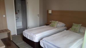 2 camas en una habitación pequeña con espejo en Der Heidkrug en Verden