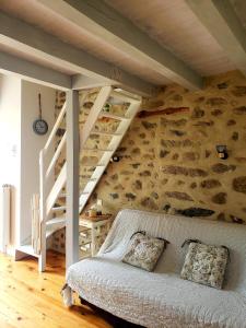 um quarto com um sofá e escadas num quarto em La Chabanade em Saint-Pierre-Eynac