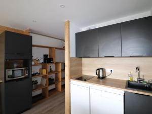 a kitchen with a black refrigerator and white cabinets at Appartement Tignes, 2 pièces, 6 personnes - FR-1-502-290 in Tignes