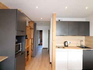 a kitchen with white cabinets and wood floors at Appartement Tignes, 2 pièces, 6 personnes - FR-1-502-290 in Tignes