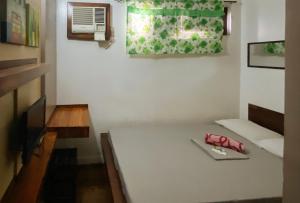 RedDoorz @ Sukitel Budget Hotel Nasugbu في ناسوغبو: غرفة صغيرة مع طاولة ونافذة