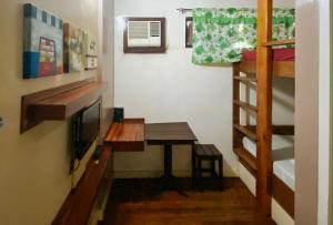 a room with a desk and a tv and a bunk bed at RedDoorz @ Sukitel Budget Hotel Nasugbu in Nasugbu