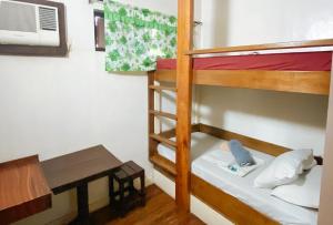 Zimmer mit 2 Etagenbetten und einem Schreibtisch in der Unterkunft RedDoorz @ Sukitel Budget Hotel Nasugbu in Nasugbu