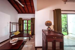 ein Wohnzimmer mit einem Bett und einem Tisch in der Unterkunft Leaf Watagala in Avissawella