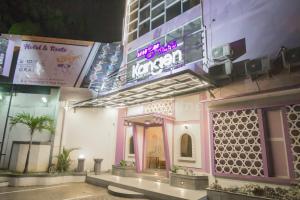 a building with a neon sign on the side of it at Ungu Kangen Hotel Bogor Mitra RedDoorz in Bogor