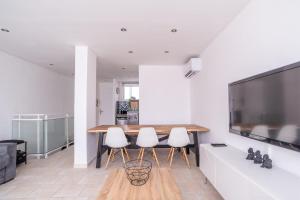 jadalnia z drewnianym stołem i białymi krzesłami w obiekcie Sublime 71m Downtown And Near The Beach ! w mieście Le Lavandou