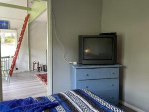 Holiday home UDDEVALLA XXVIII في أوديفالا: غرفة نوم مع تلفزيون فوق خزانة