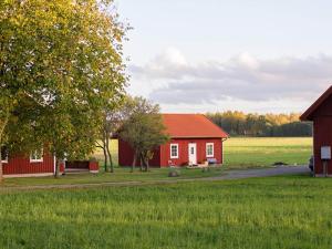 a red barn and a red house in a field at Holiday home GÖTENE II in Götene