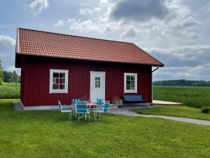 een rood huis met een tafel en stoelen ervoor bij 6 person holiday home in GÖTENE-By Traum in Götene
