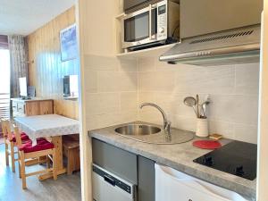 a small kitchen with a sink and a microwave at Studio Tignes, 1 pièce, 3 personnes - FR-1-502-322 in Tignes
