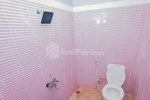 a pink bathroom with a toilet in a room at Ungu Kangen Hotel Bogor Mitra RedDoorz in Bogor