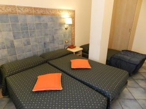 a room with a bed with orange pillows on it at Hotel Punta Mesco in Monterosso al Mare