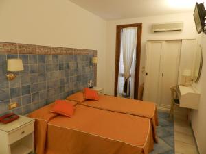 - une chambre avec 2 lits avec des draps orange dans l'établissement Hotel Punta Mesco, à Monterosso al Mare