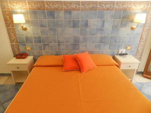 a bedroom with an orange bed with two orange pillows at Hotel Punta Mesco in Monterosso al Mare