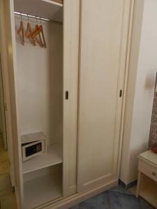 a closet with white cabinets and a clock at Hotel Punta Mesco in Monterosso al Mare