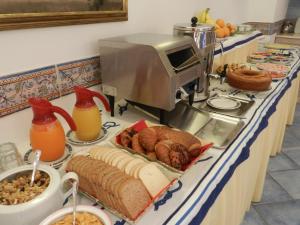 a breakfast buffet with bread and orange juice and other foods at Hotel Punta Mesco in Monterosso al Mare