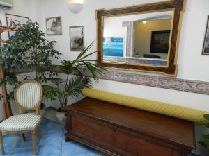 a mirror on a wall with a chair and a bench at Hotel Punta Mesco in Monterosso al Mare