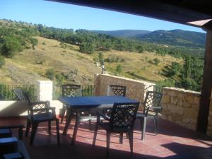 a blue table and chairs on a balcony with a view at La Tejada del Valle in Valle de San Pedro